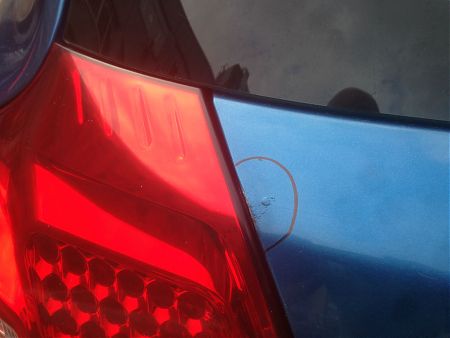 Очаг ржавчины на крышке багажника KIA Ceed в месте прилегания к заднему фонарю
